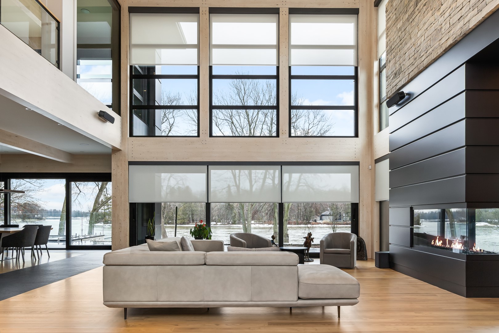 Light-colored roller shades across two stories of living room windows